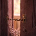 FP相談を怪しいと感じて、鎖のかかった扉を少しだけ開けている様子